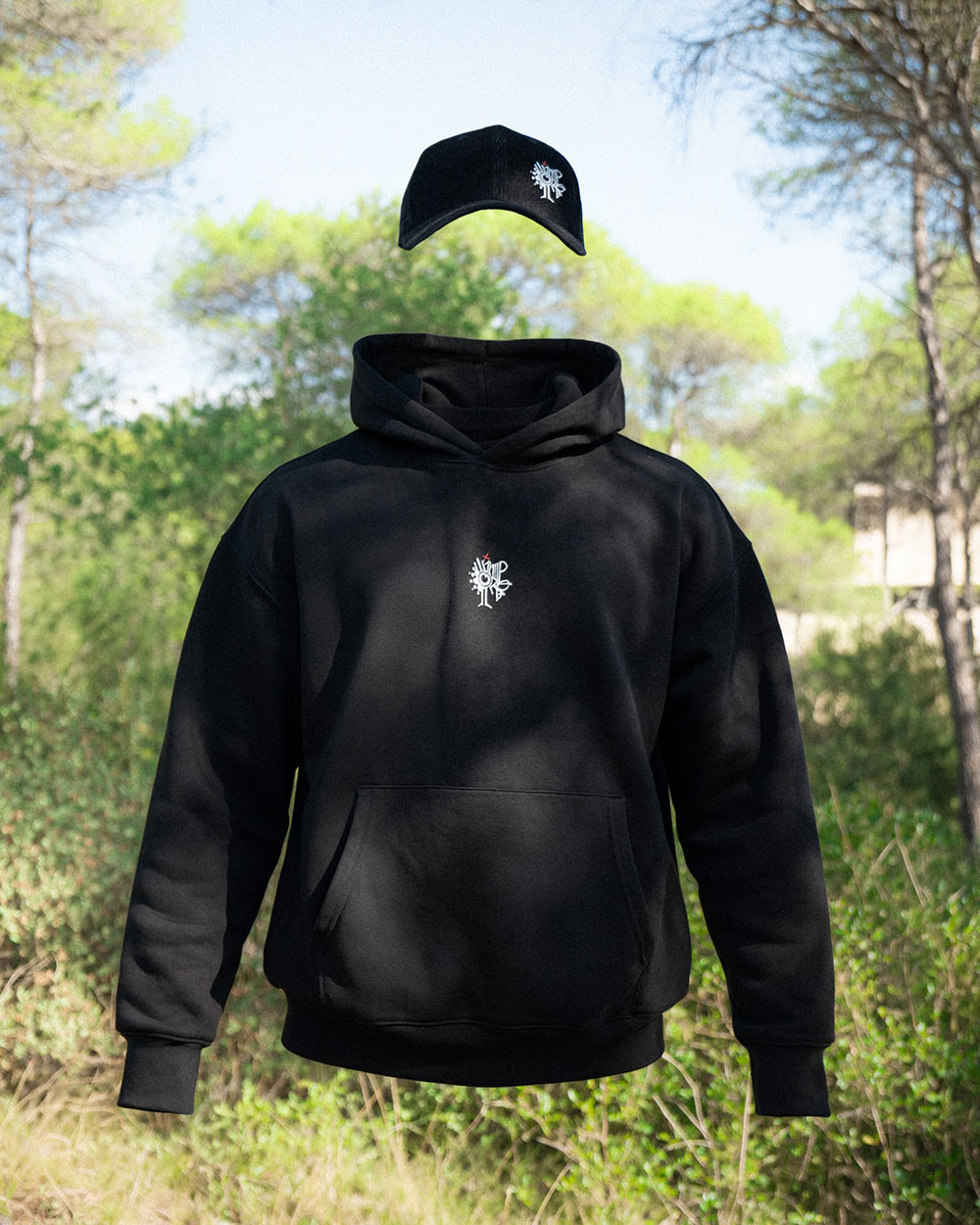 Hoodie et casquette improbables noirs suspendus dans une pinède